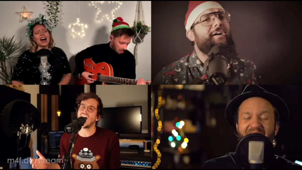 Festliche Weihnachtsmusik: Vier Sänger mit Mikrofonen, Weihnachtsmütze und festlicher Dekoration.