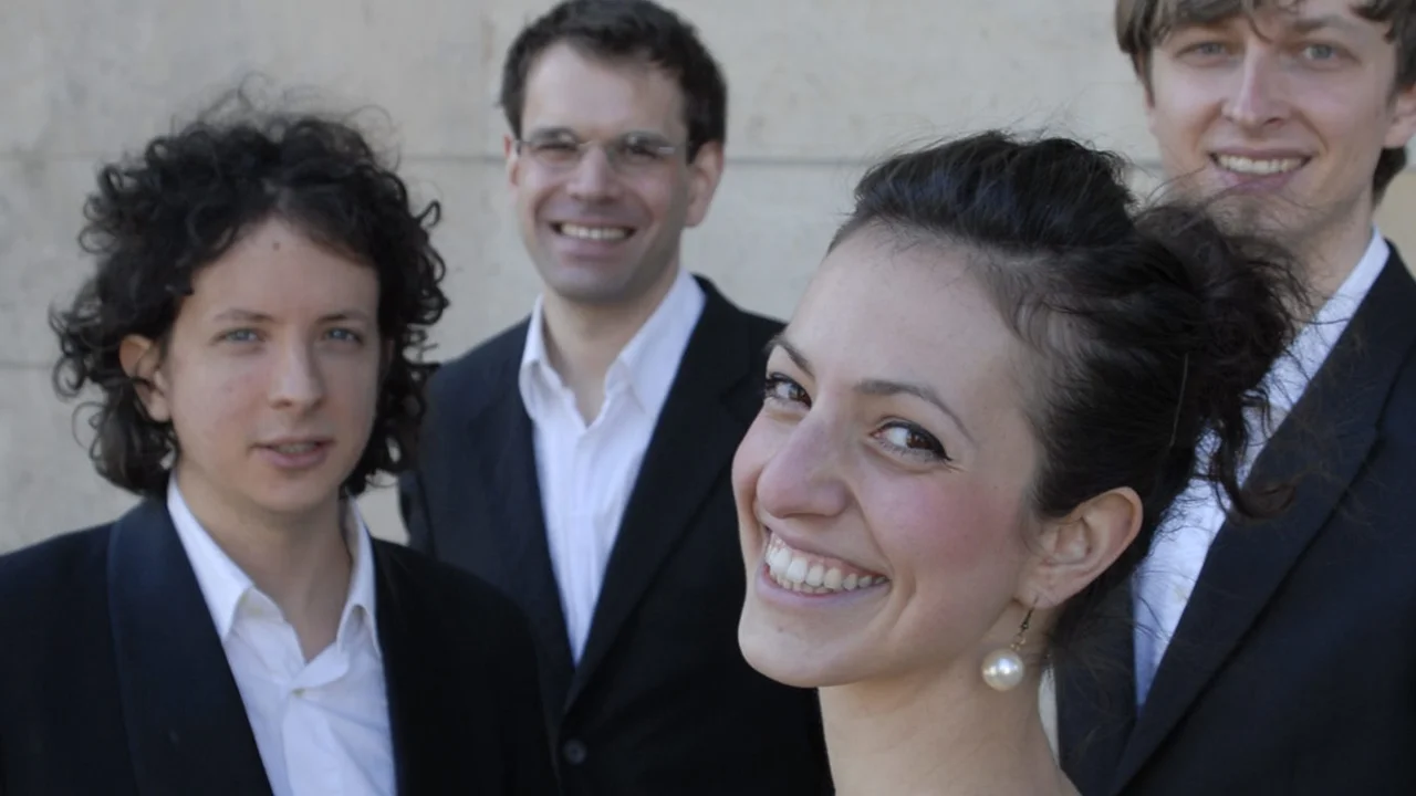 Gruppenfoto von vier Musikern beim professionellen Fotoshooting mit eleganter Kleidung.