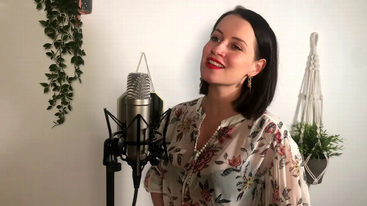 Lea Christine singt und performt vor Mikrofon in einem kreativen, natürlichen Studio.