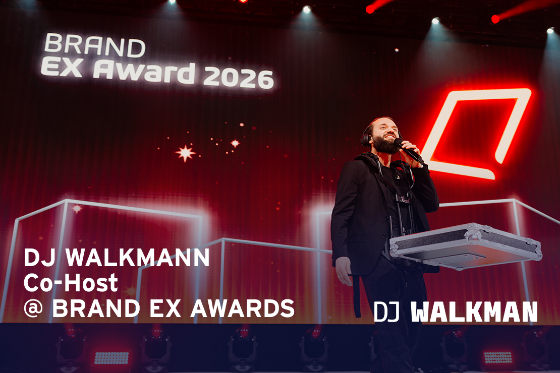 DJ WALKMAN auf Bühne mit mobilem Setup vor großer LED Wand mit Text BRAND EX AWARDS 2026 mit Mikro für Ansage