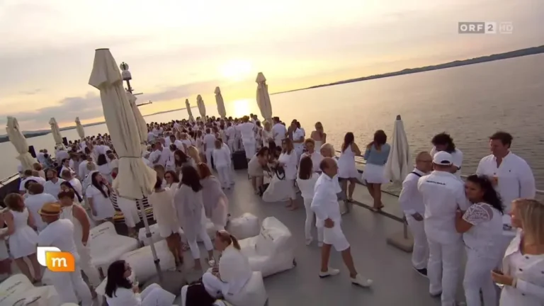Elegante Party auf einem Boot bei Sonnenuntergang mit weißen Outfits und entspannten Gästen.