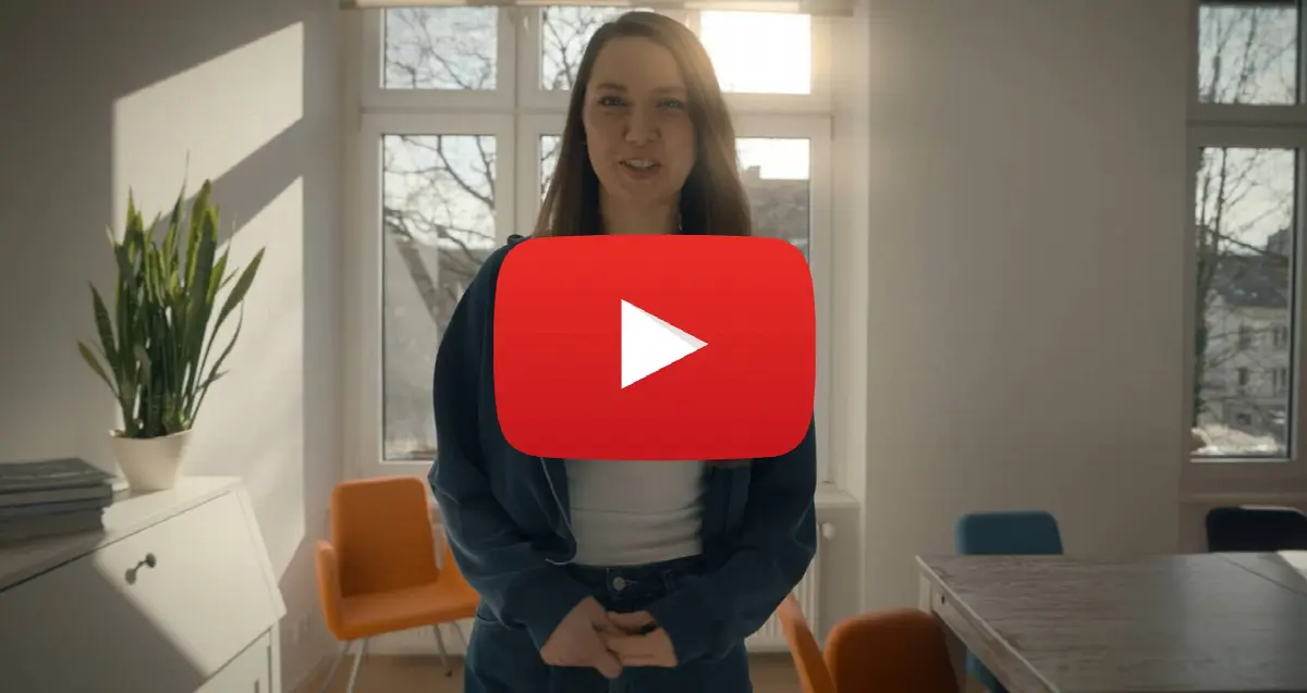 Junge Frau erklärt im modernen Büro mit Naturlicht, Pflanzen und farbigen Stühlen.