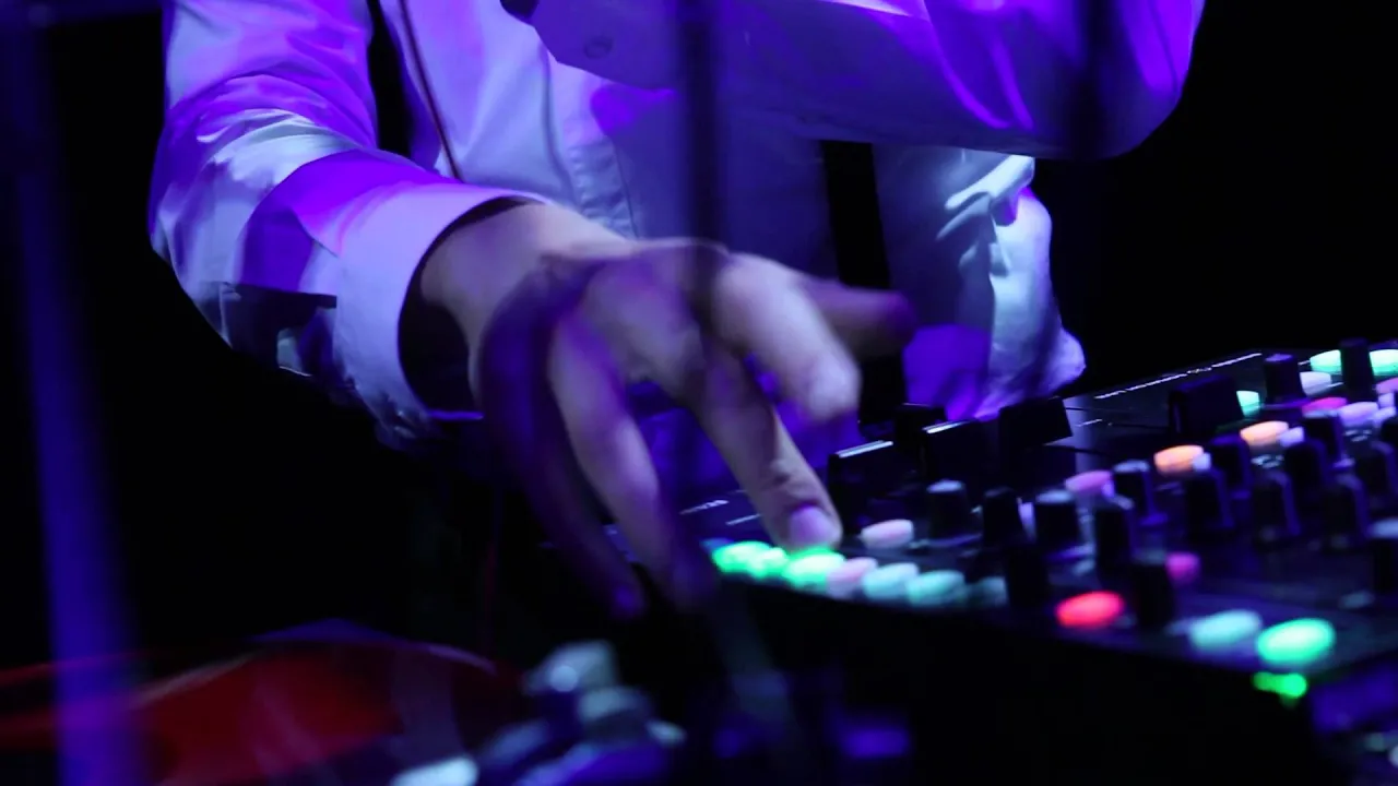 DJ beim Live-Mixing mit Licht, Knöpfen und energiegeladenem Club-Atmosphäre.