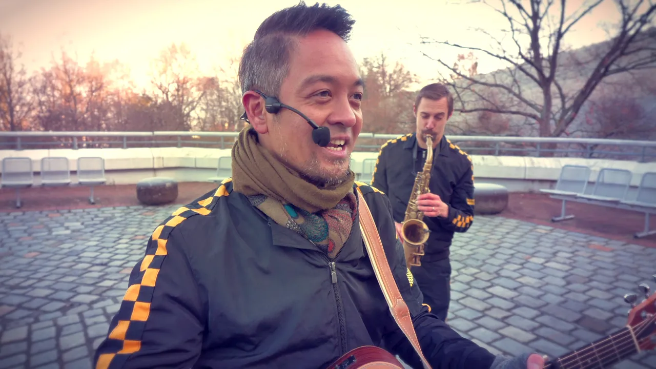 Musiker mit Gitarre und Saxophon bei Live-Performance im urbanen Winter.