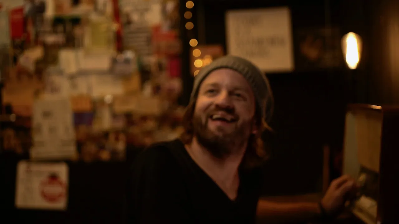 Musiker bei live Musik in gemütlicher Bar mit nostalgischer Dekoration und fröhlichem Lachen.