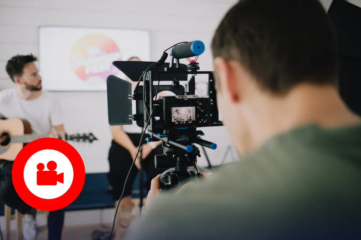 Professionelle Videoproduktion mit Musiker und Kamera-Setup in modernem Studio.