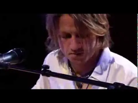 Pianist spielt leidenschaftlich Live-Musik bei stimmungsvoller Beleuchtung auf einer Bühne.