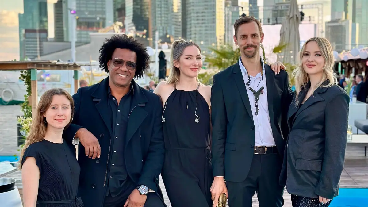 Vip-Kunden-Event auf modernem Rooftop mit Stadtblick bei Sonnenuntergang.